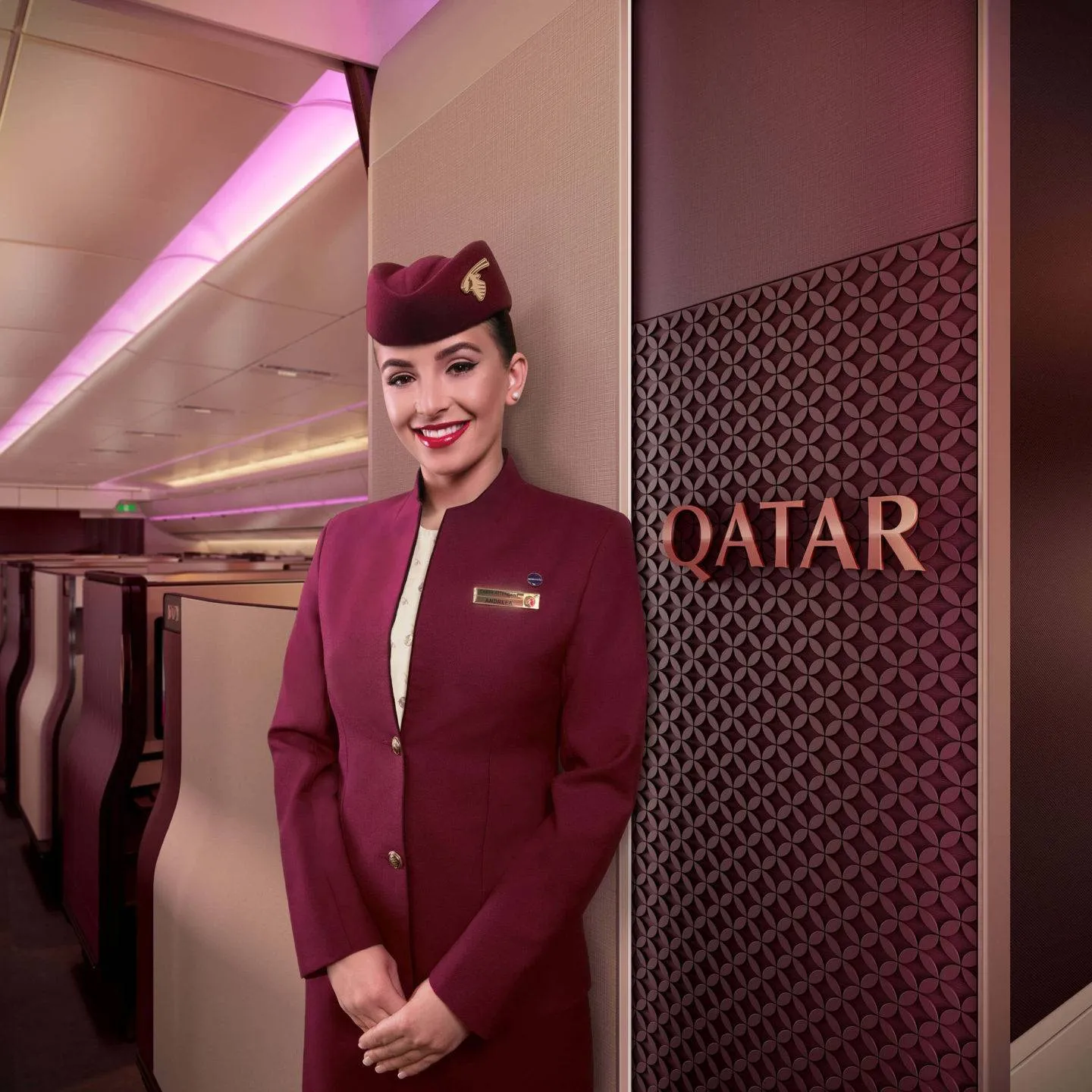 Cabin crew stands next to a branded entrance panel