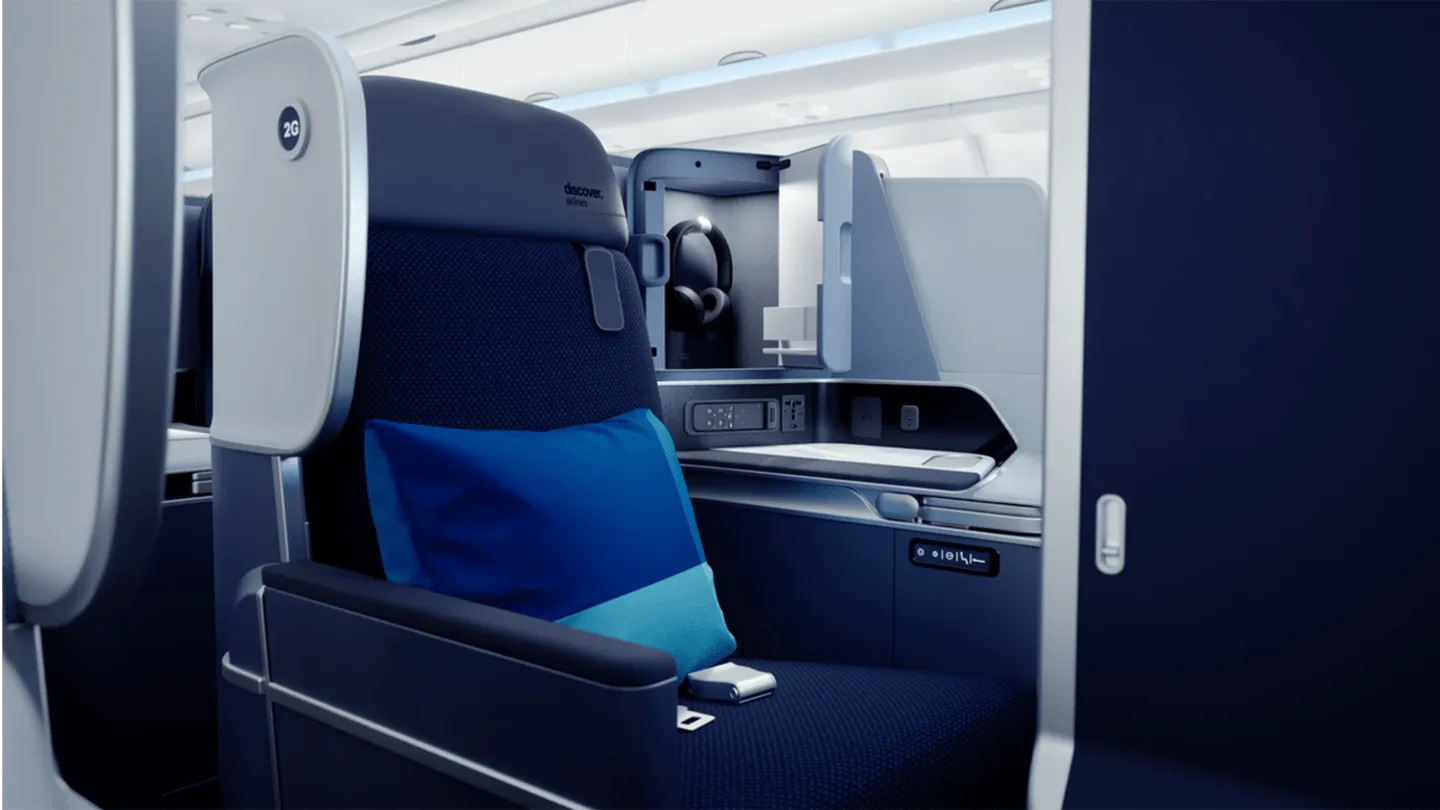Discover Airlines cabin interior with blue and white seats and overhead lighting, designed by PriestmanGoode.