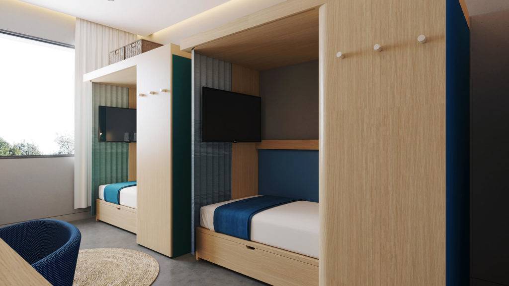 Two enclosed bed spaces. There is a TV on the wall in each bed space, as well as three coat hooks on the outside. Space above the bed units is used for storage