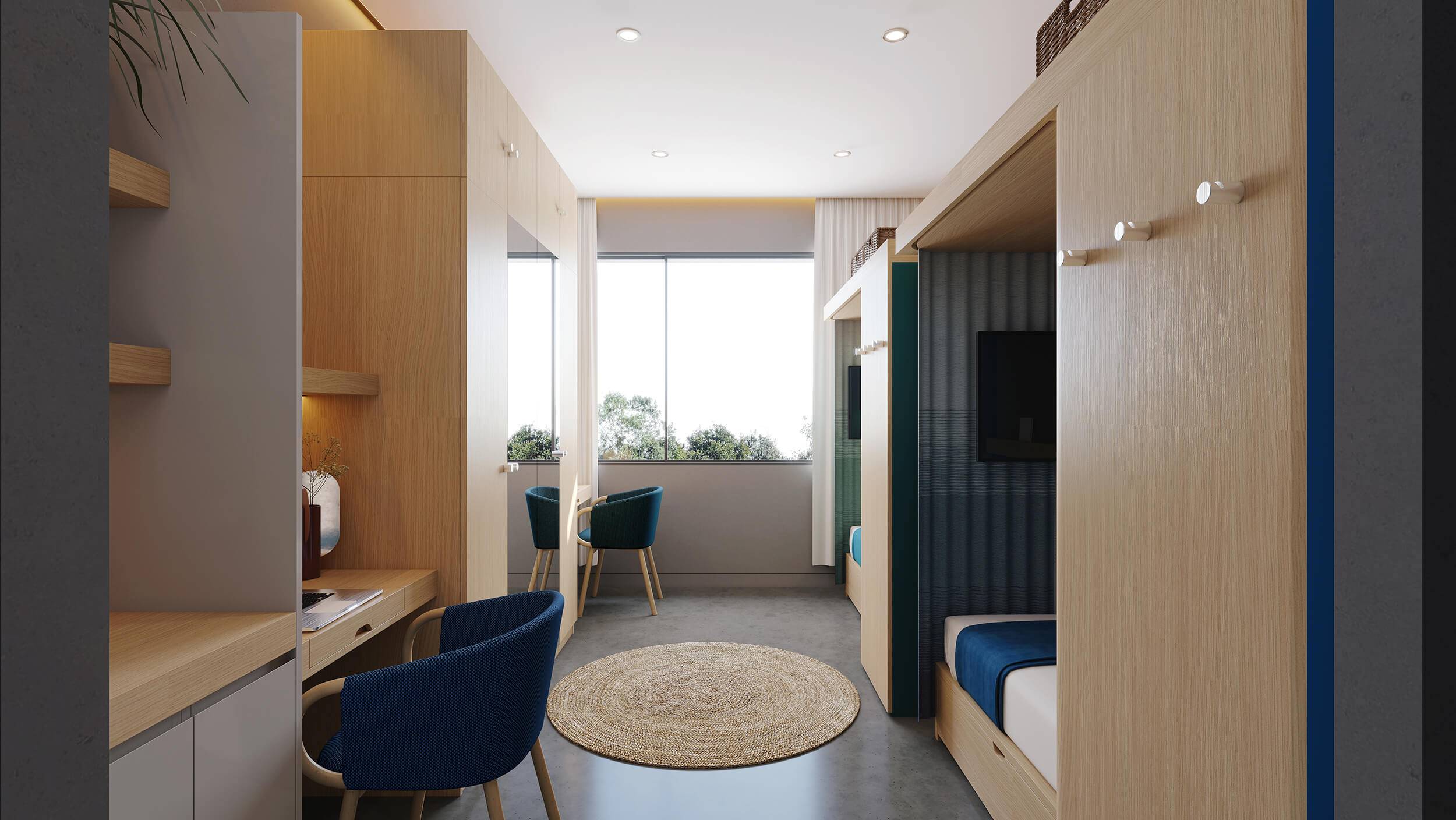 A view of a bedroom with two identical enclosed beds on the right, and wardrobes, two desks and two chairs on the left. A round rug is in the middle of the room, and large window in the back