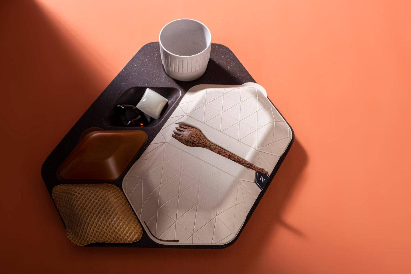 An airline mealtray made of sustainable materials, including wafer biscuit, algae, coffee grounds and coconut wood