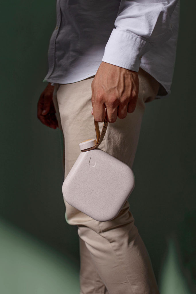 A man holds a square reusable water bottle made from sustainable materials