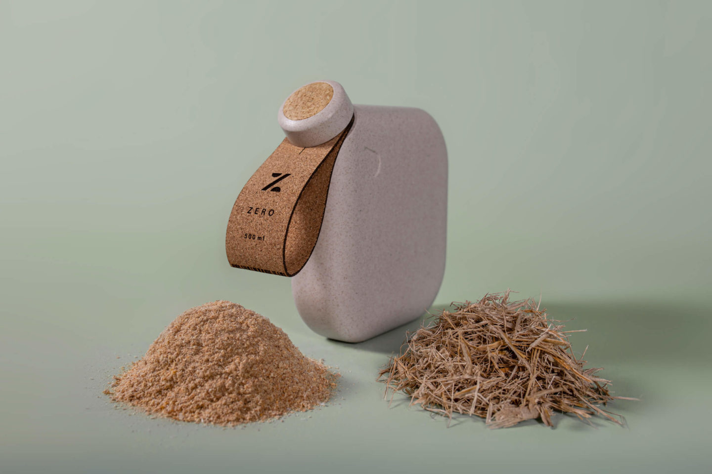 A square water bottle made from sustainable materials, shown alongside the raw materials it is made of