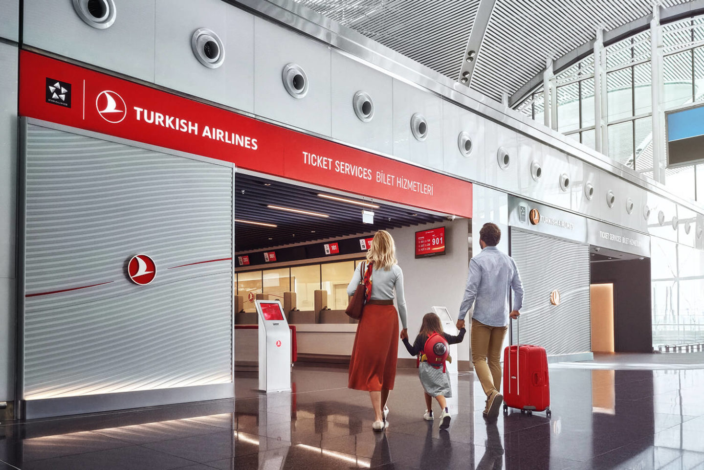 A young family walking towards Turkish Airlines ticket services at New Istanbul Airport