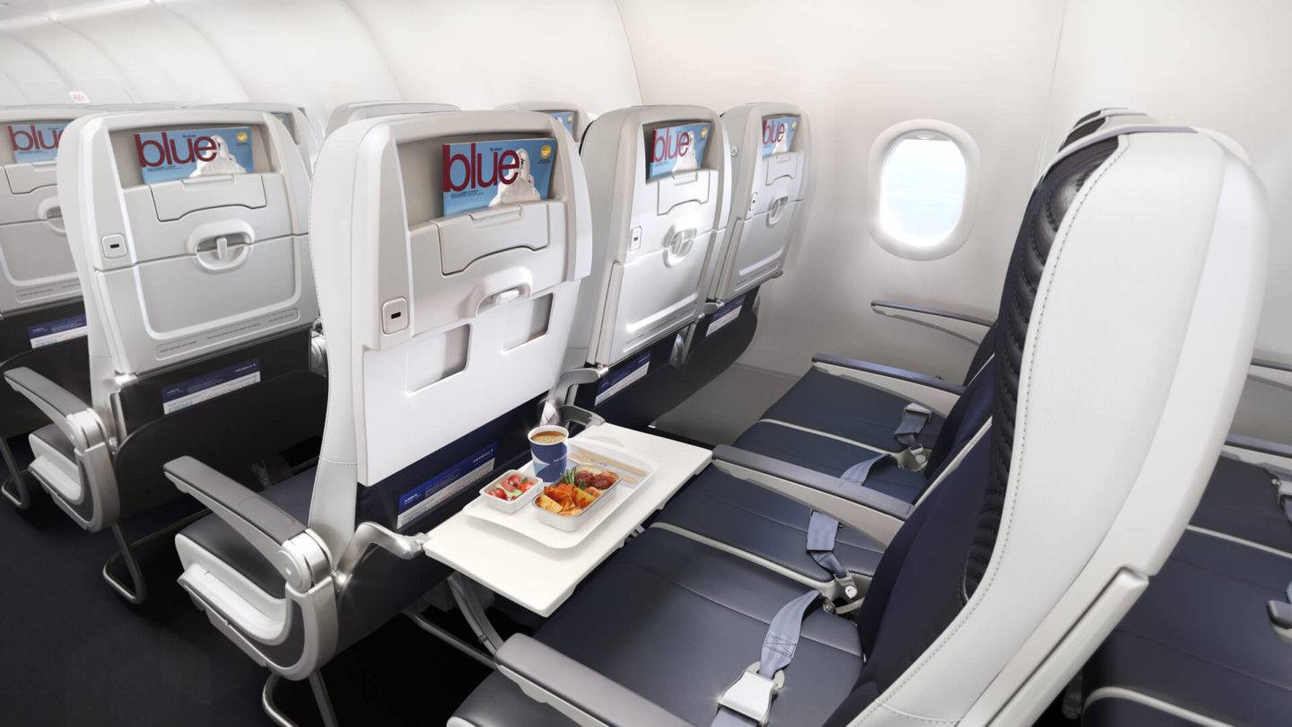 Side view of an Aegean Airlines Economy Seat on the Neo aircraft. The table on the aisle seat is down, with a tray of food and drink