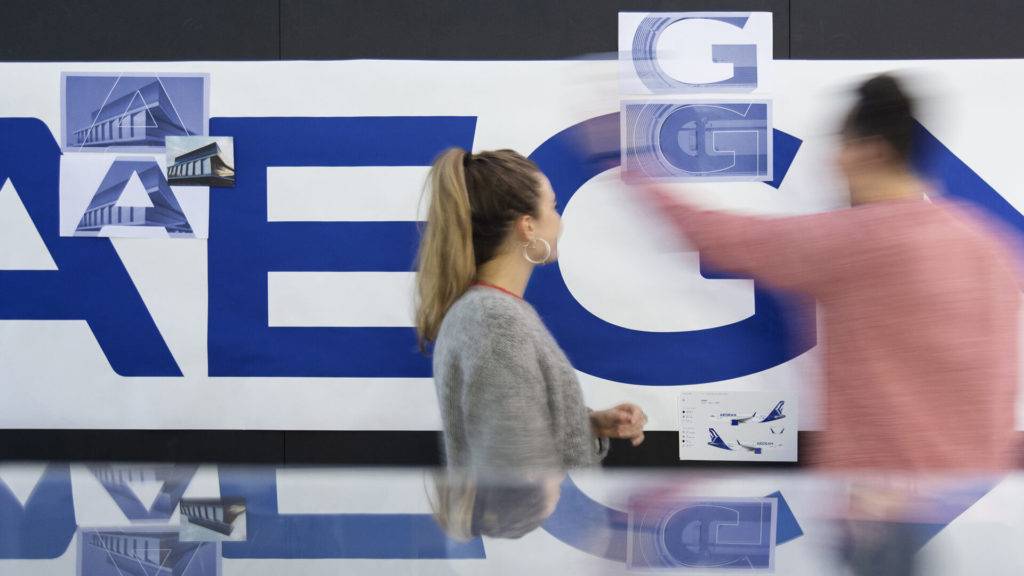 Two designers looking at typography details of the new Aegean Airlines brand