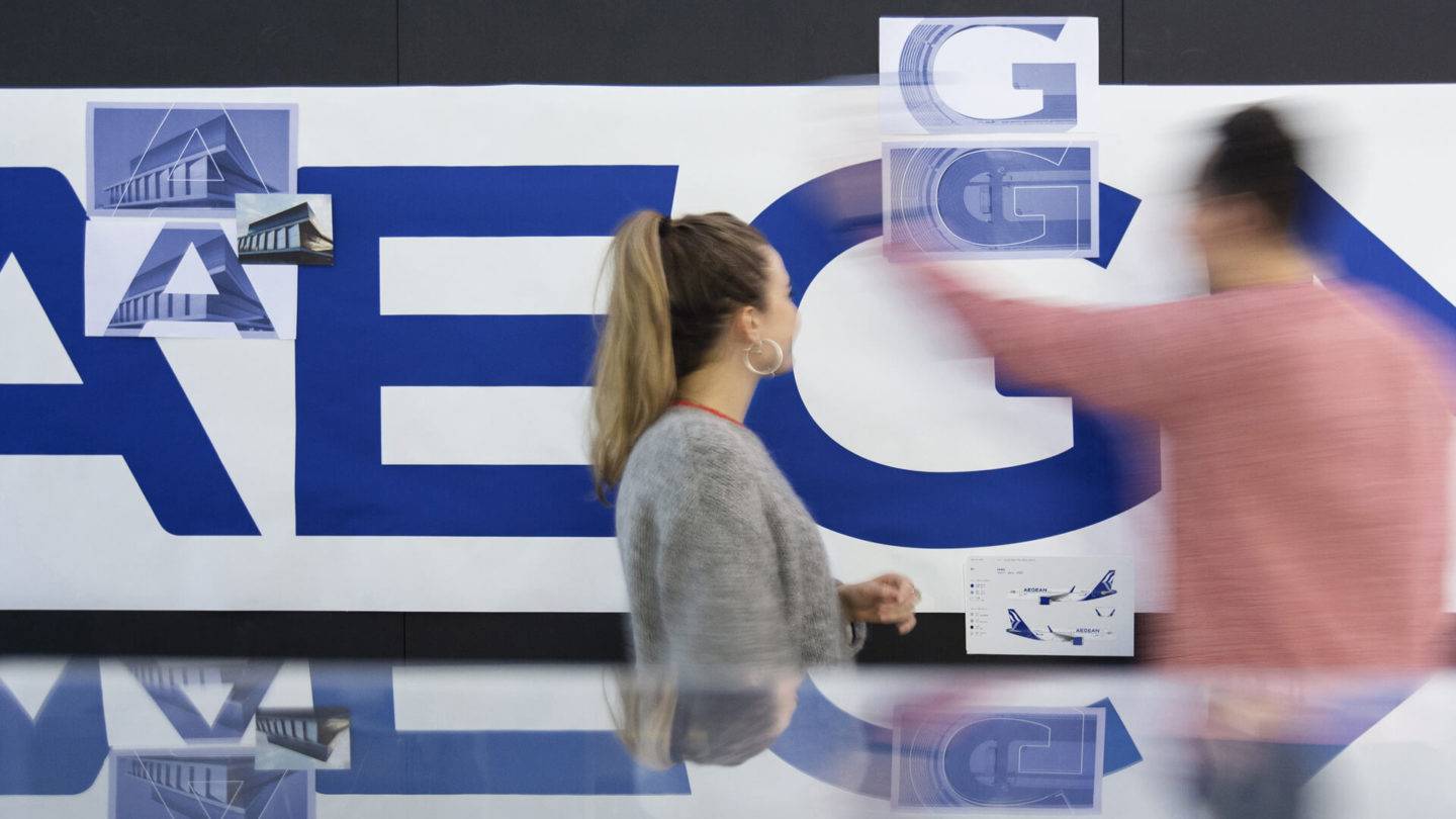 Two designers looking at typography details of the new Aegean Airlines brand