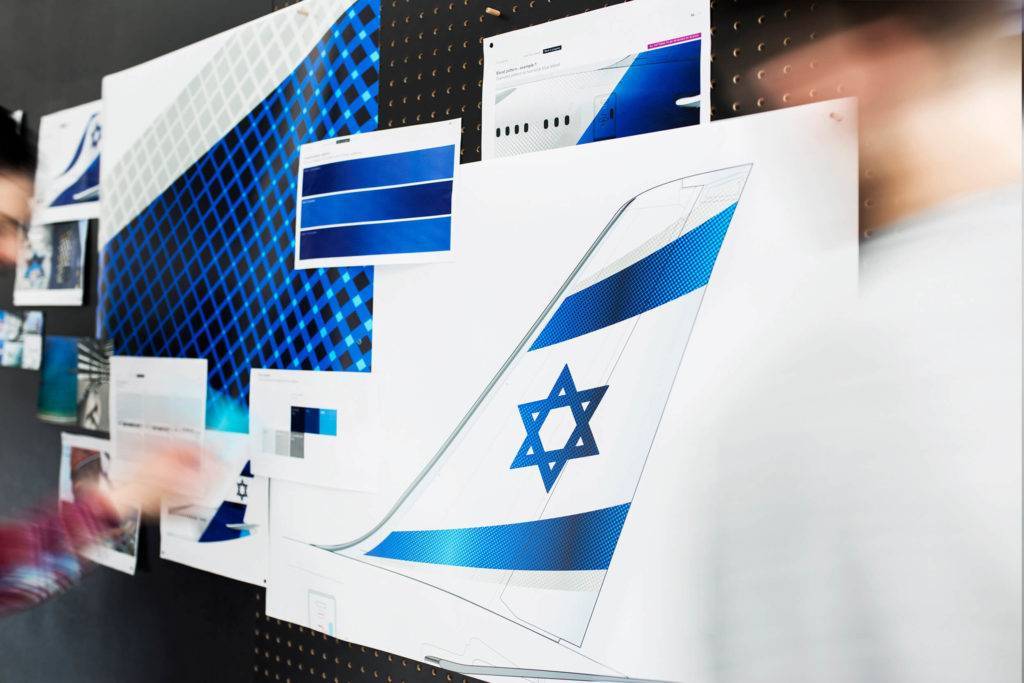 A selection of images pinned to a board showing sketches of the El Al livery on an aircraft tailfin and a selectin of blue colours and patterns