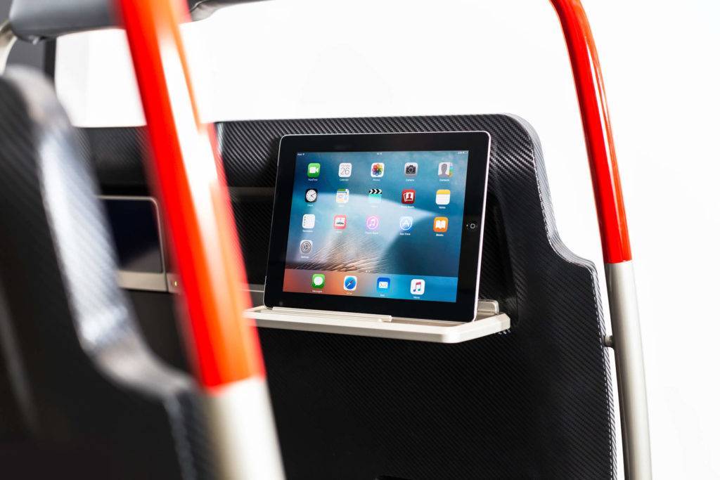 A tablet is on a slim table folded down from the back of the Horizon train seat