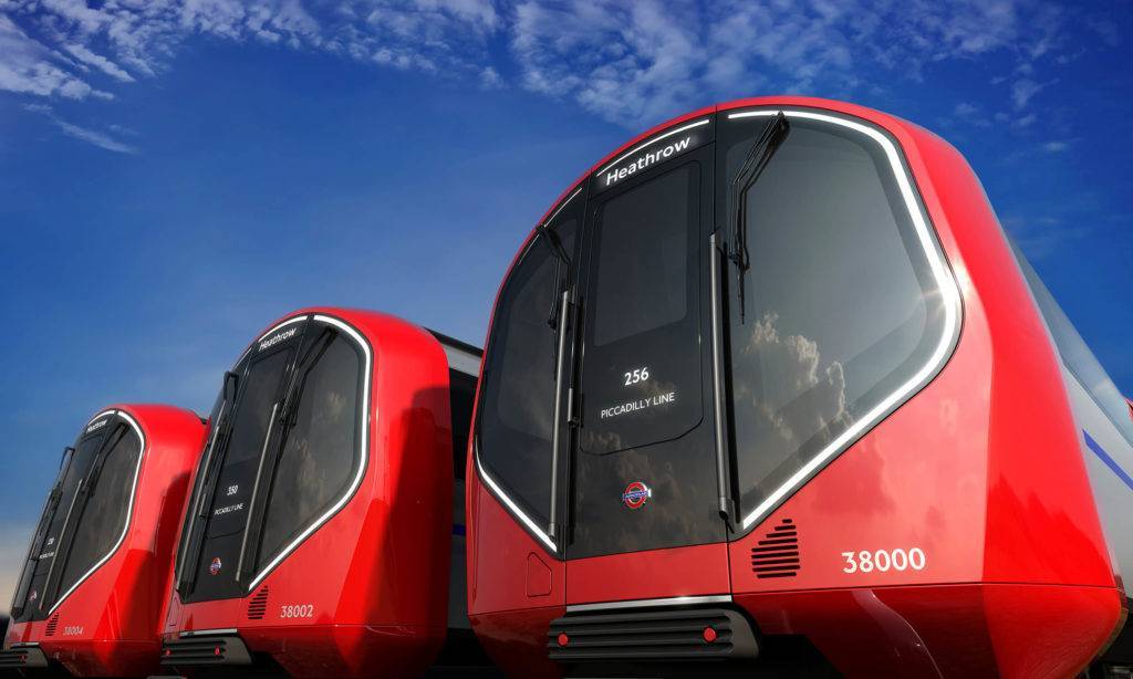 The front of three London Underground train carriages shown in daytime, with a blue sky above