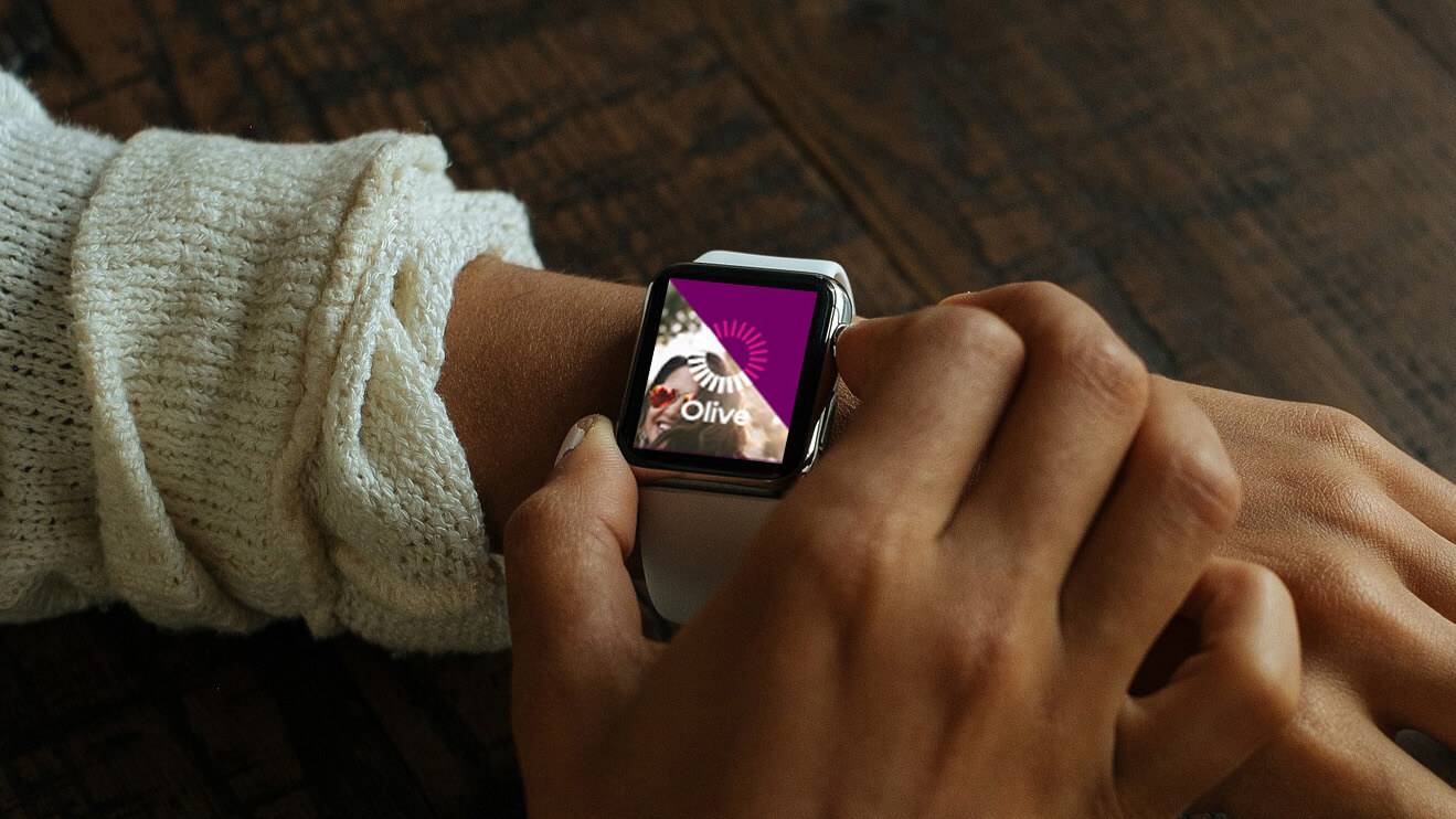 Close of two hands as a person looks at the Olive app on their wrist watch