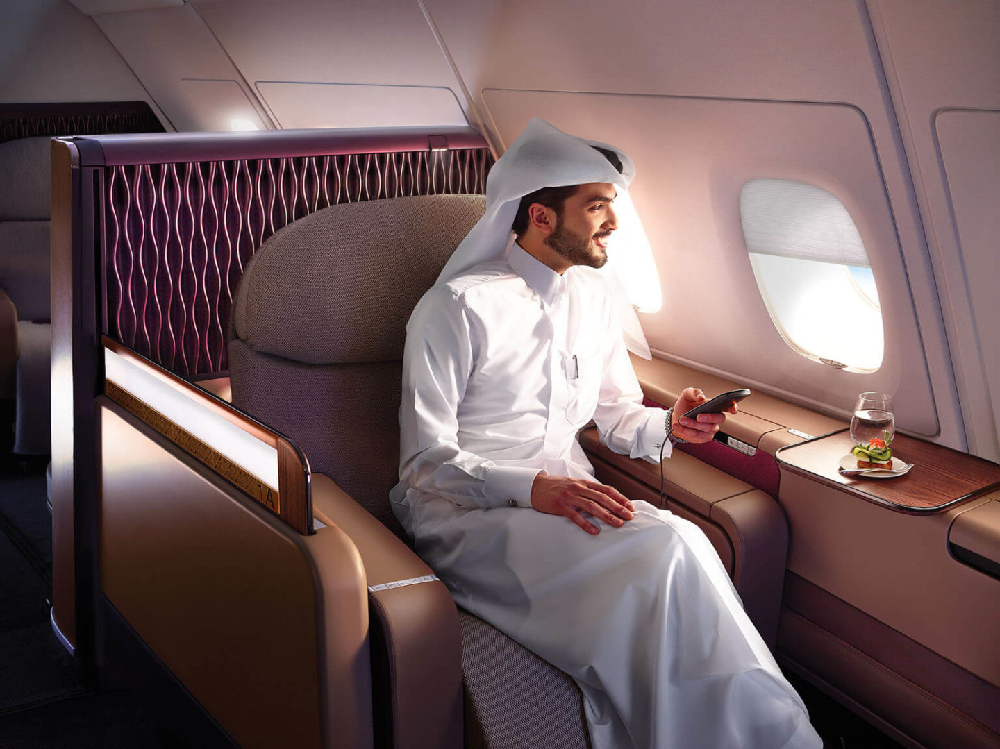 A passenger seated in a luxurious First Class seat onboard Qatar Airways A380