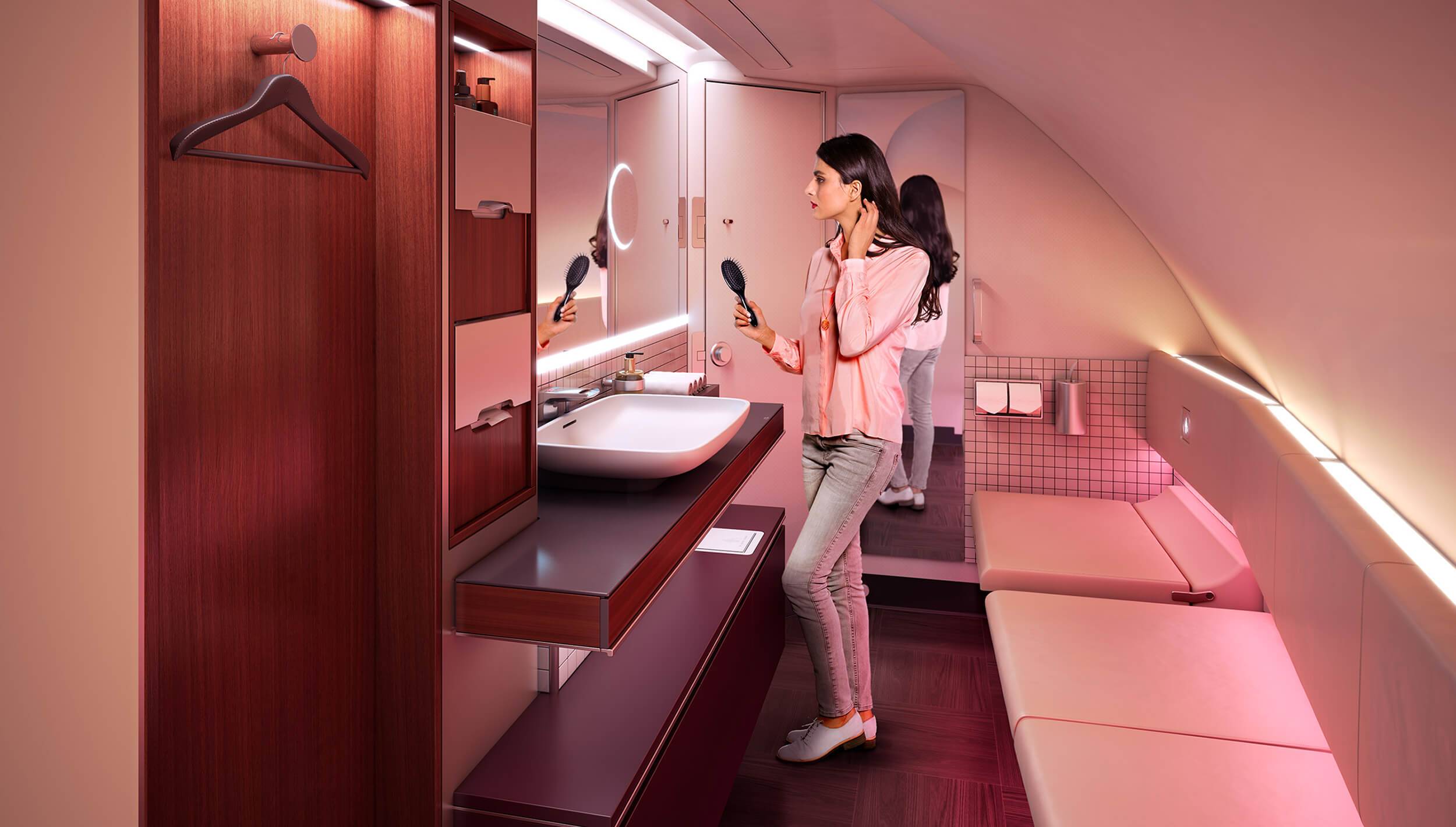 A woman stands in front of a large mirror in the luxurious Premium bathroom on Qatar Airways A380