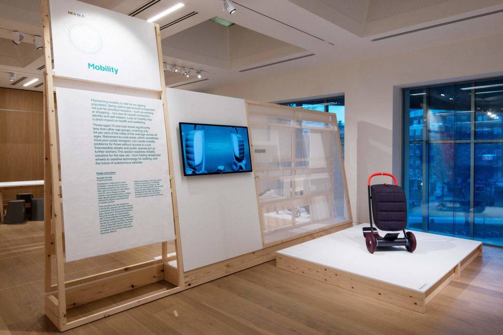 The Scooter for Life seen on a platform in an exhibition, alongside text and a screen which display further information