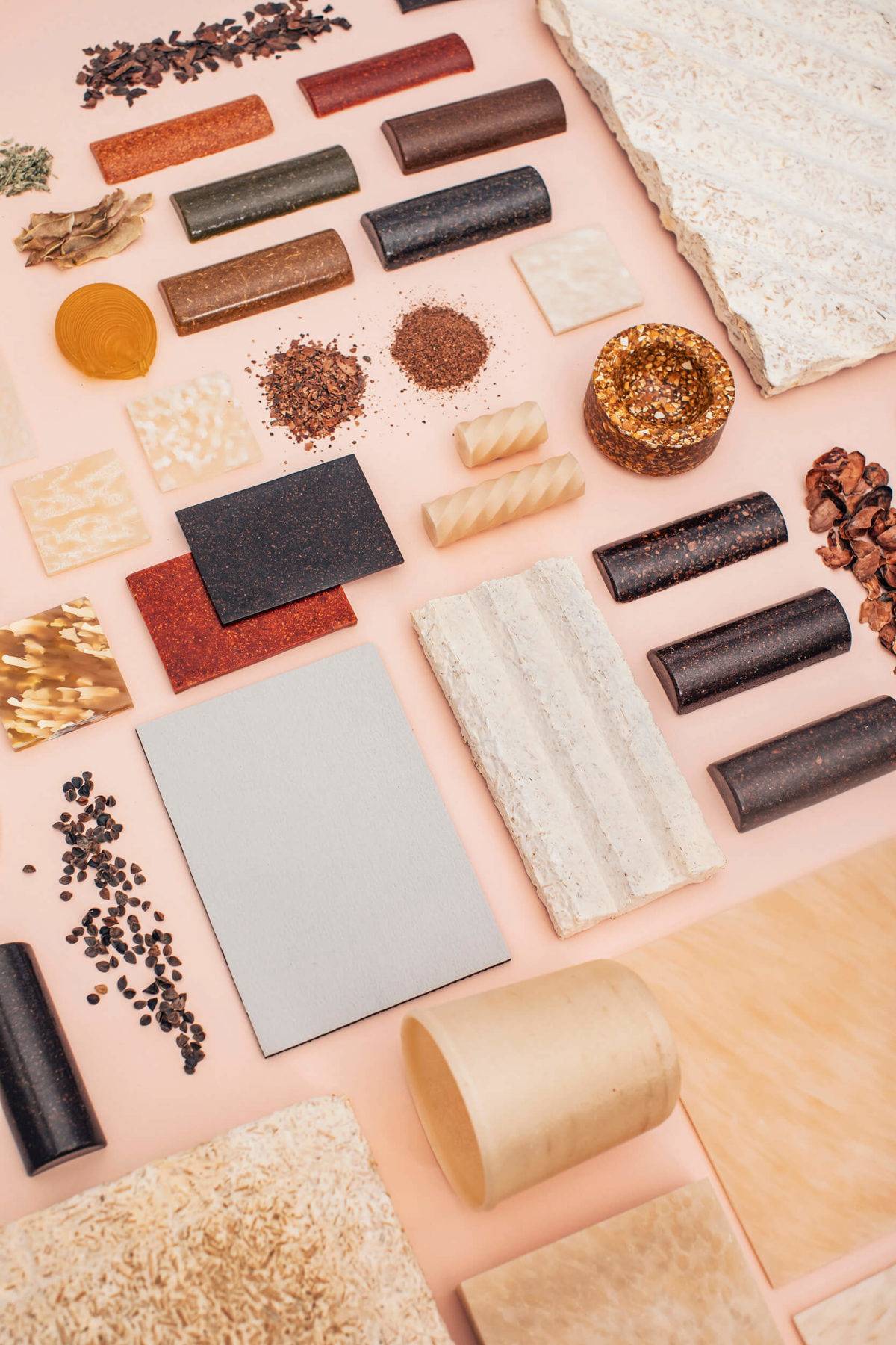 A large selection of natural material samples laid out on a light pink background