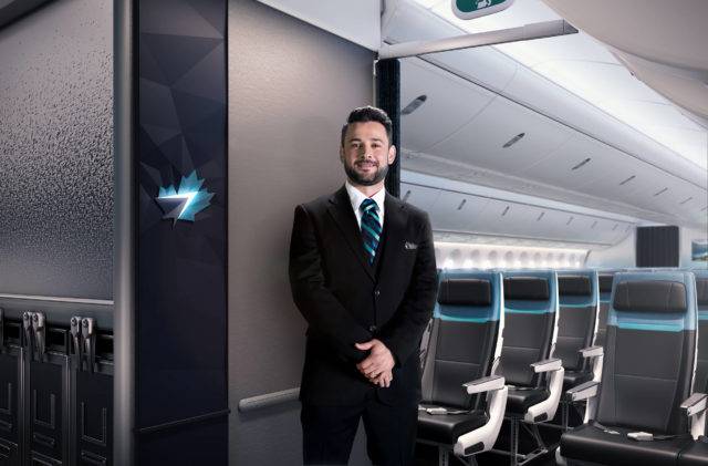 A cabin crew stands next to a brand panel with the WestJet logo at the entrance of the aircraft