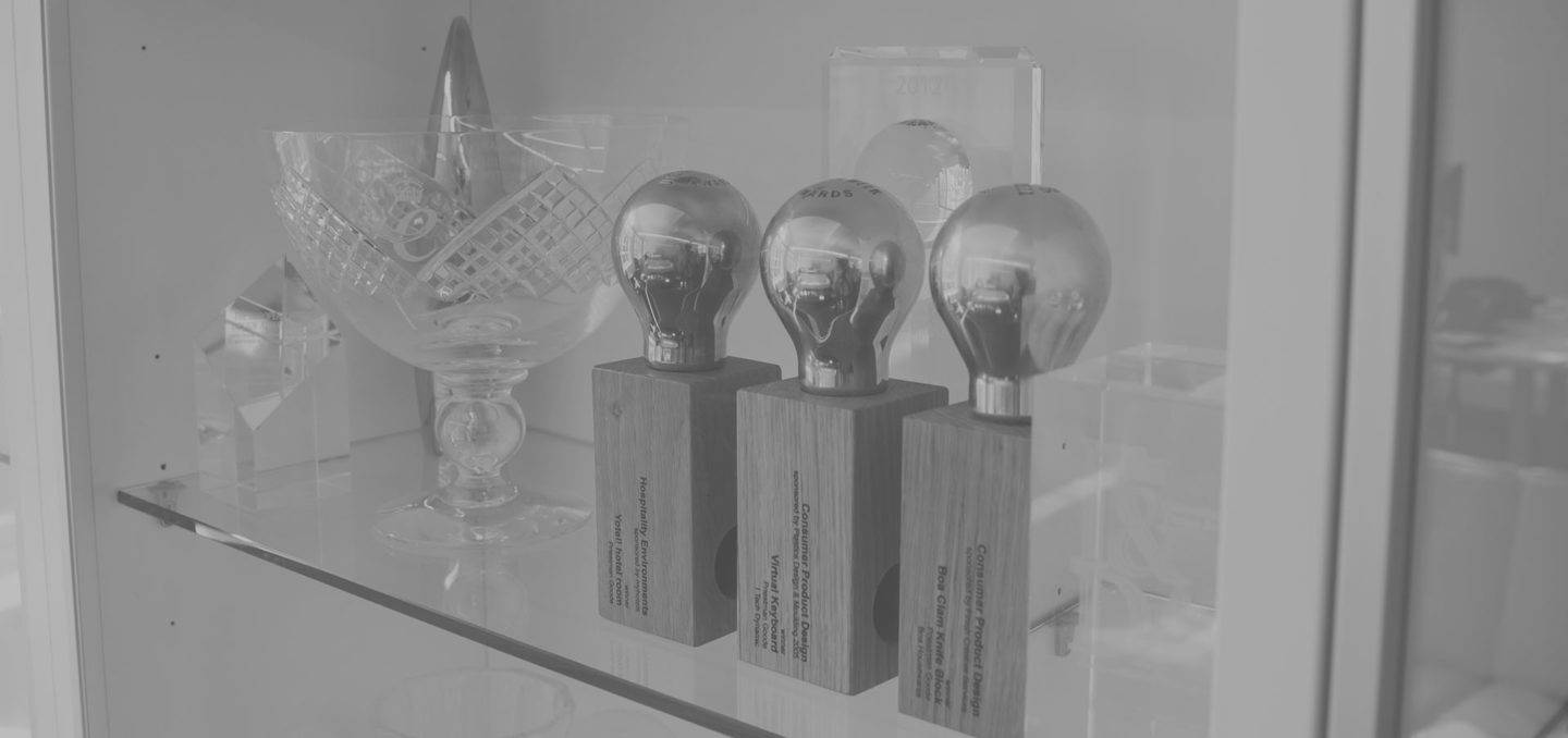 Awards on a glass shelf in a cabinet