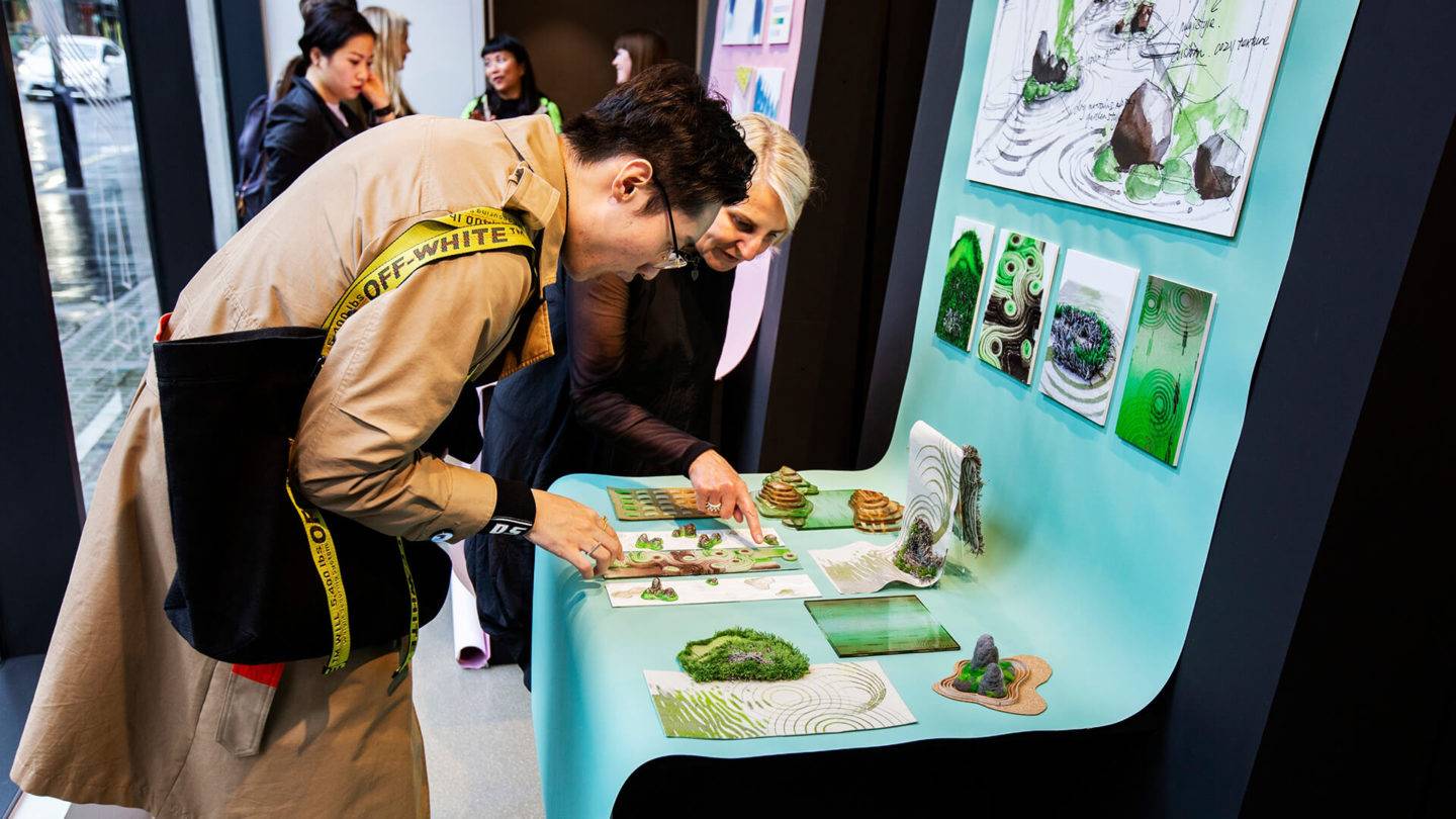 People looking down at a series of material samples and images in an exhibition