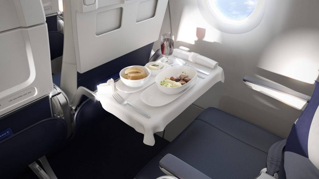 Close up of the Business Class meal on Aegean Airlines, with cloth covered seat tray, glassware, cutlery and more