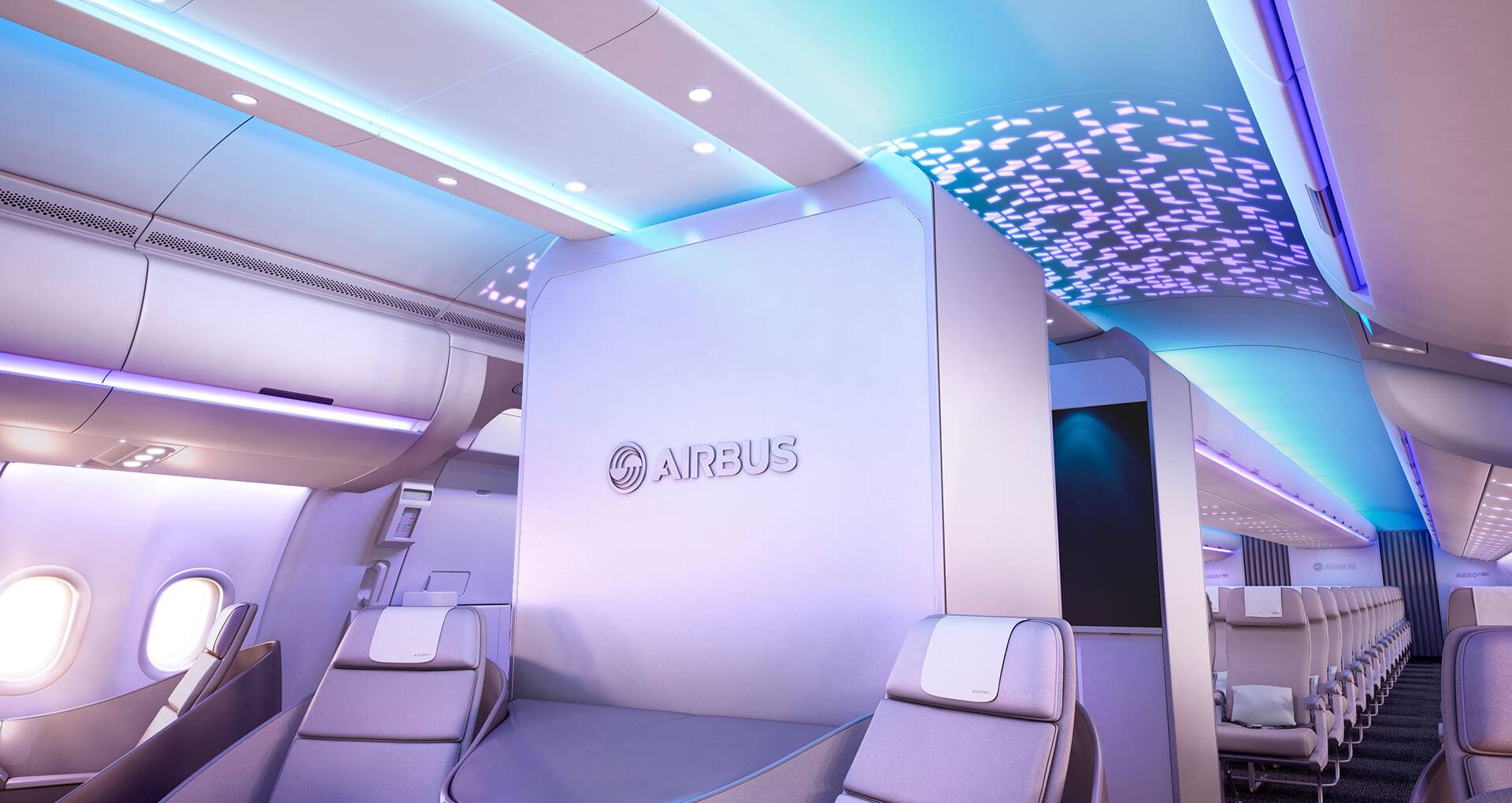 Airbus 3D logo on a bulkhead in Business Class on the A330neo Airspace cabin. The Economy cabin can be seen in the back. An intricate pattern features on the ceiling in the space between Business and Economy class