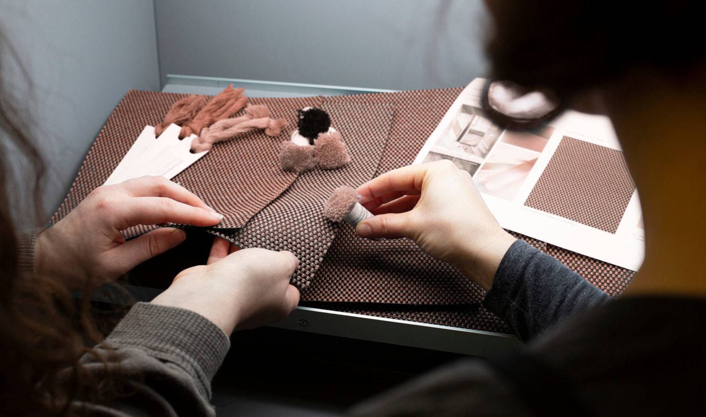 Two people looking at material and thread samples