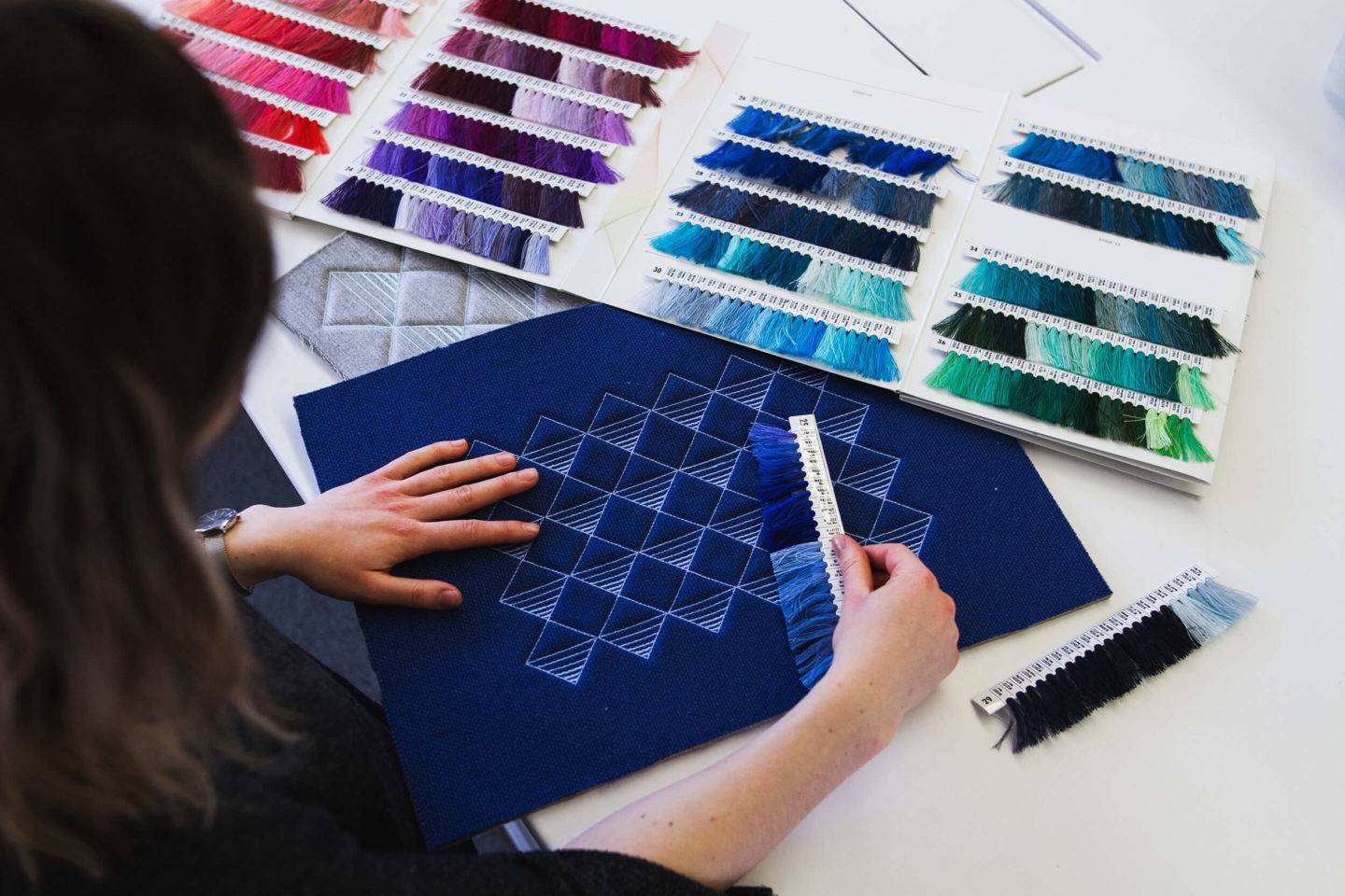 Person looking at material and thread samples