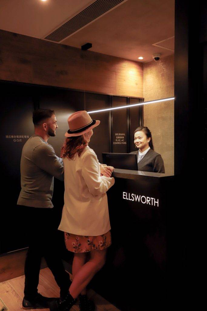 Two people and a concierge at a reception desk