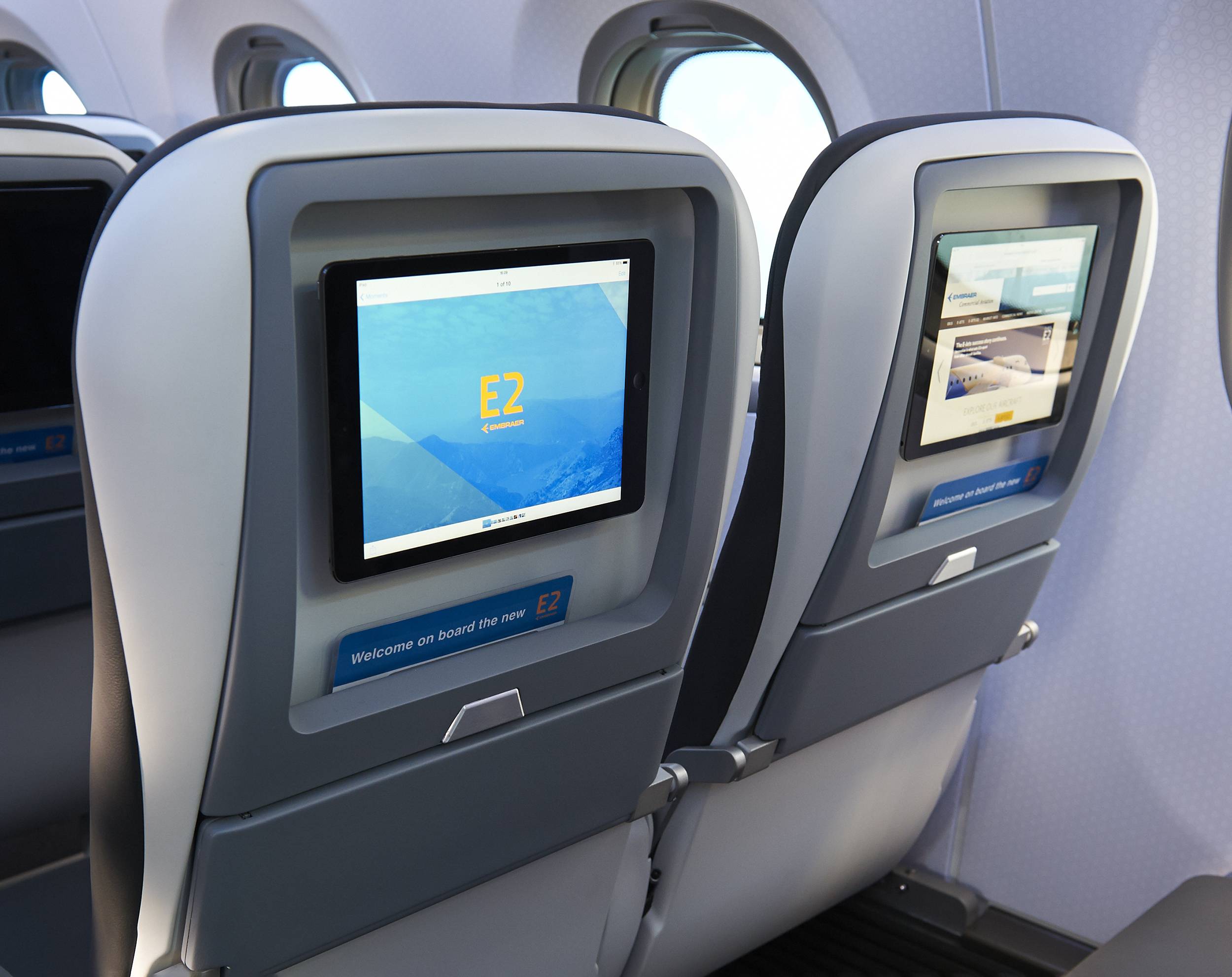 Back of aircraft seats showing IFE screens with a bespoke designed GUI for the Embraer E2 jet