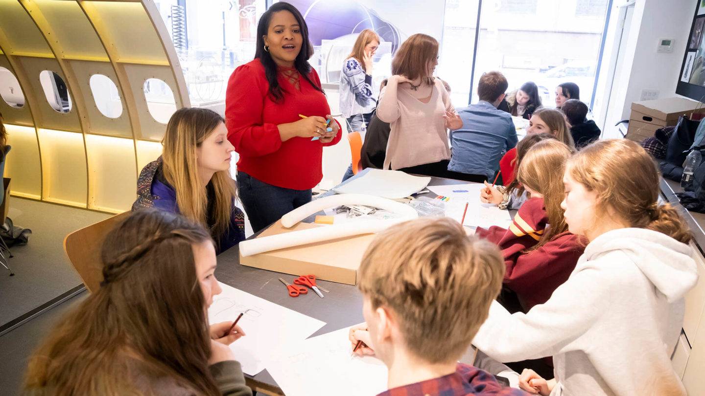 A group of young people in a workshop drawing and making models from card and foam