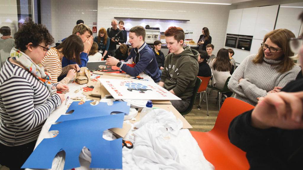 Young people during a workshop creating posters from paper and card