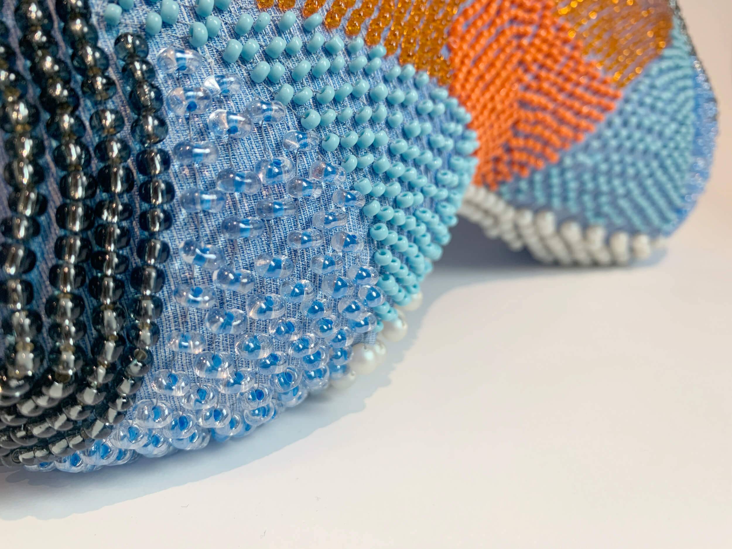Beading in shades of blue, black, coral and white on a head pillow