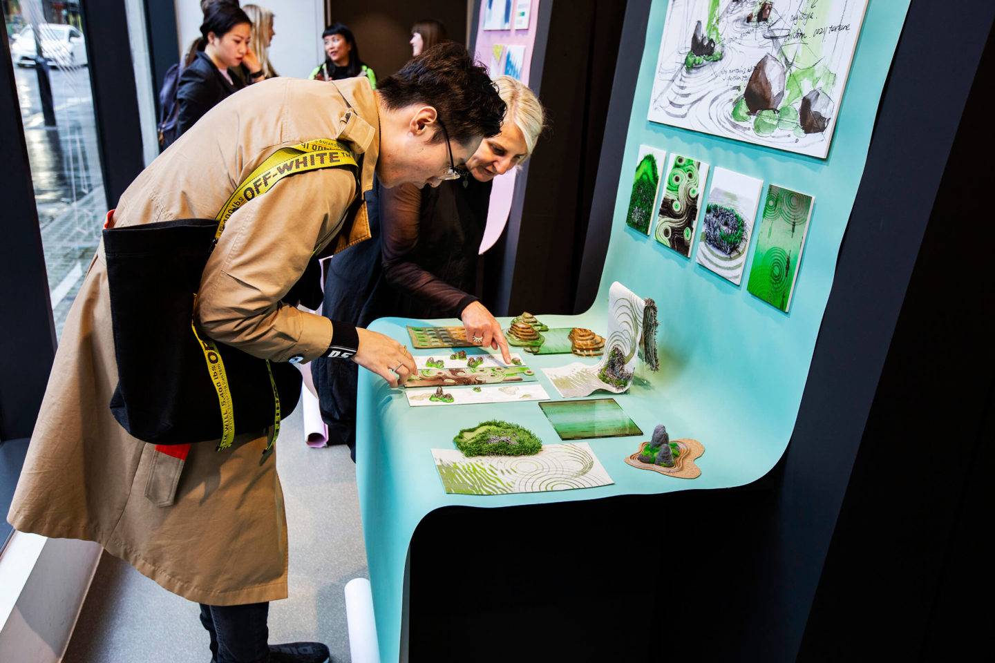 People looking down at a series of material samples and images in an exhibition