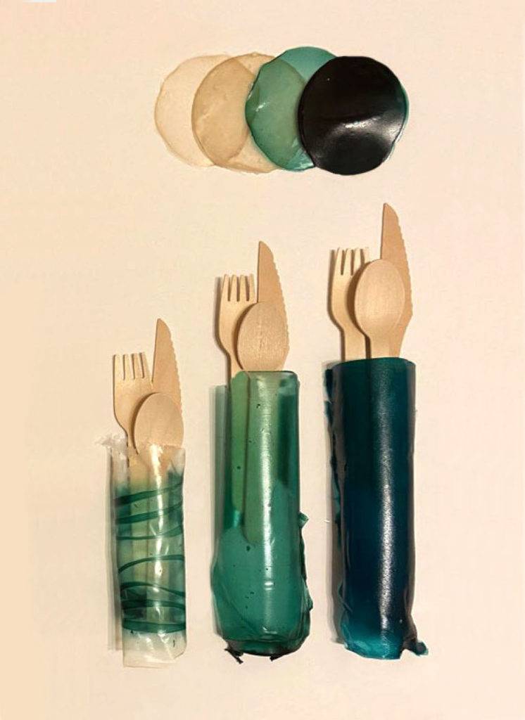 Wooden cutlery wrapped in a green translucent biodegradable plastic