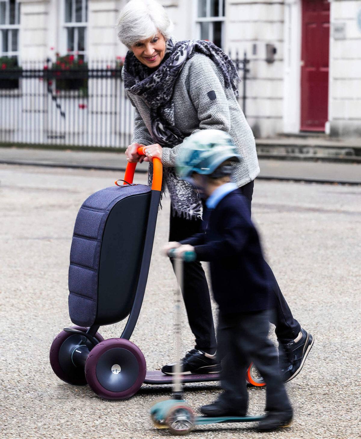 An older woman and a young boy are both riding a personal scooter