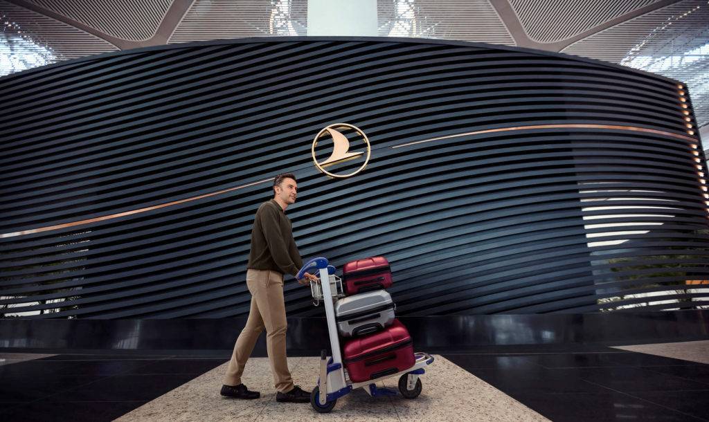 A man walking in front of an imposing branded Business Class dividing panel