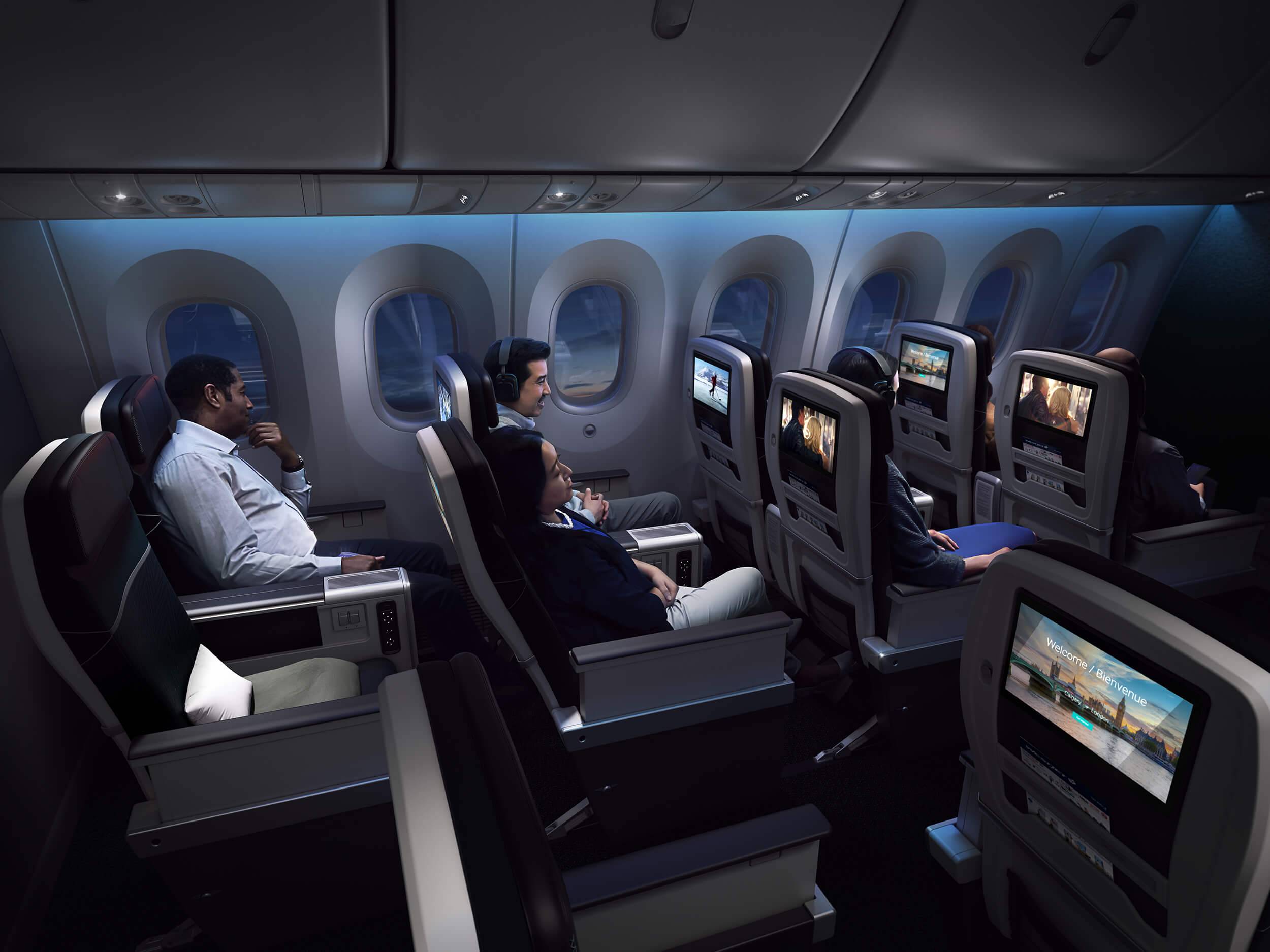 Passengers in Business Class onboard the WestJet B787 are watching TV in their seats as the night falls