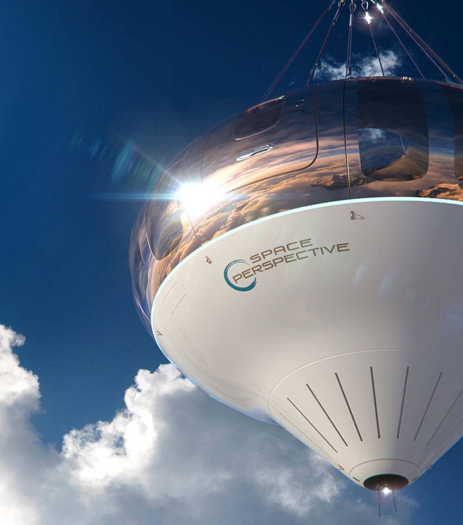A Space capsule shown in a bright blue sky, with clouds in the background