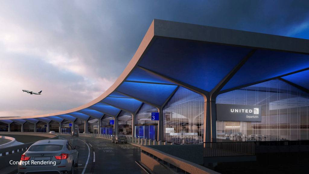 A car on a road arriving at an airport terminal building, with a lit up United Departures sign seen on the side of the building