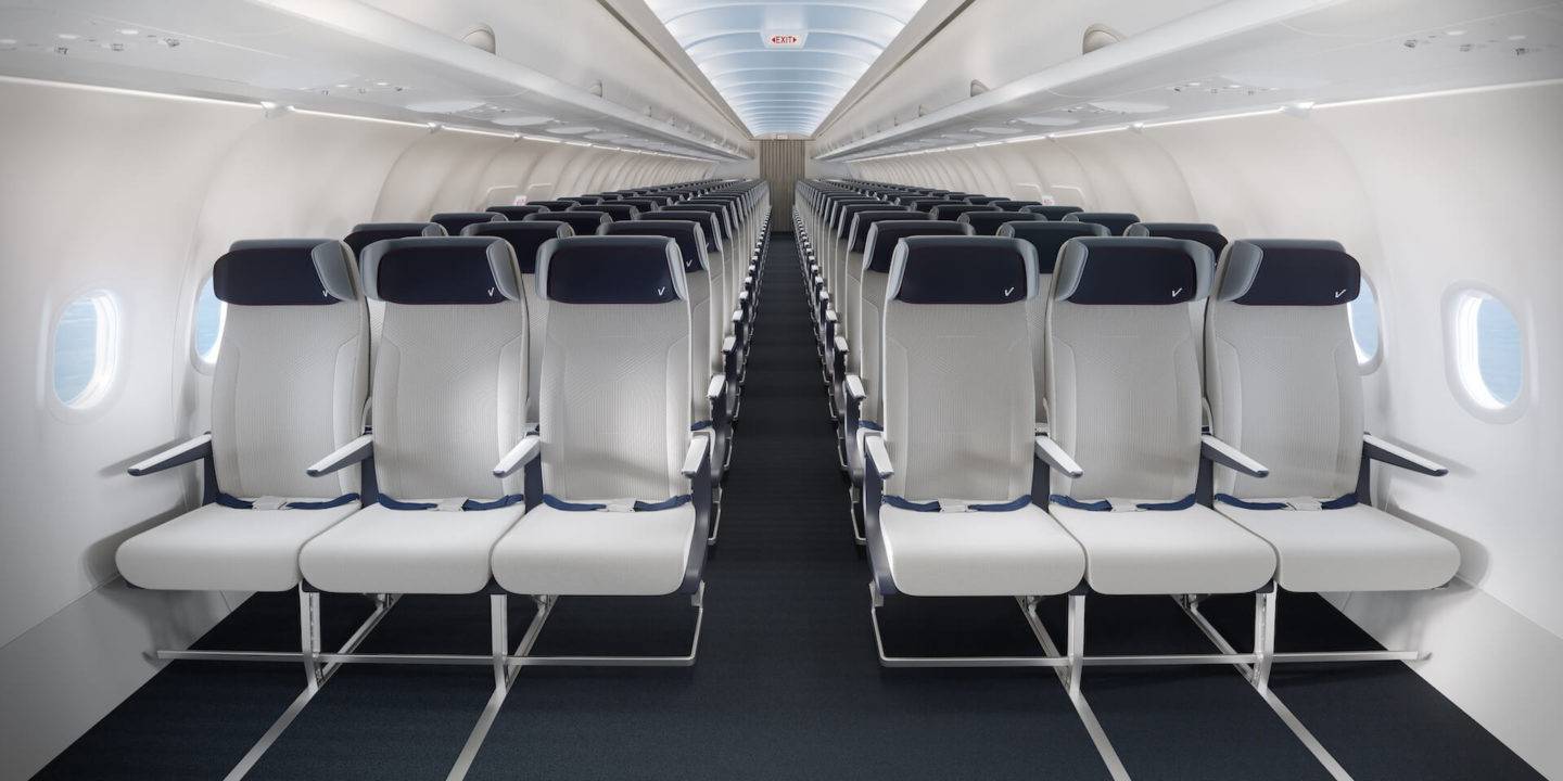 Front view of an economy class cabin showing light grey contemporary seats with dark blue headrests