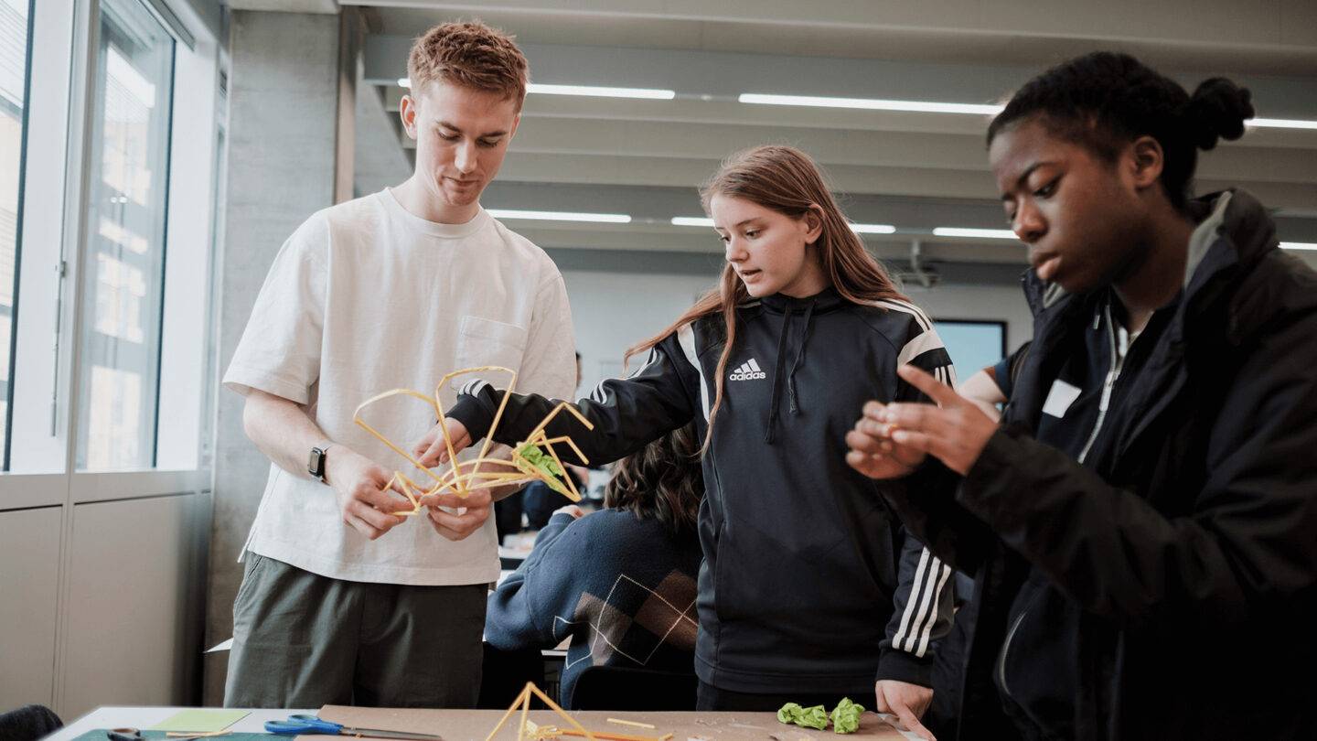 Students and Luke from PG working on a model made from straws